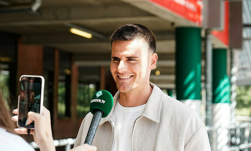 Michael Zetterer lacht und hat ein Mikrofon vor dem Mund.