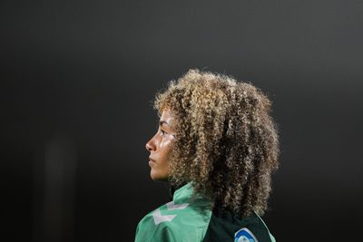 Amira Arfaoui von der Seite bei Abendhimmel, schaut nach links.