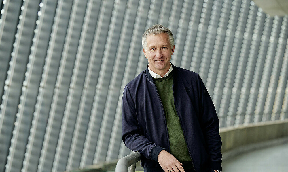 Frank Baumann steht mit Sakko im Umlauf des Weserstadions