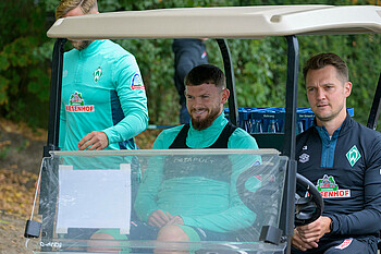 Oliver Burke im Golf Kart auf dem Weg zum Training.