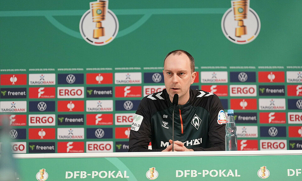 Ole Werner auf dem Podium bei der Pressekonferenz vor dem Pokalspiel