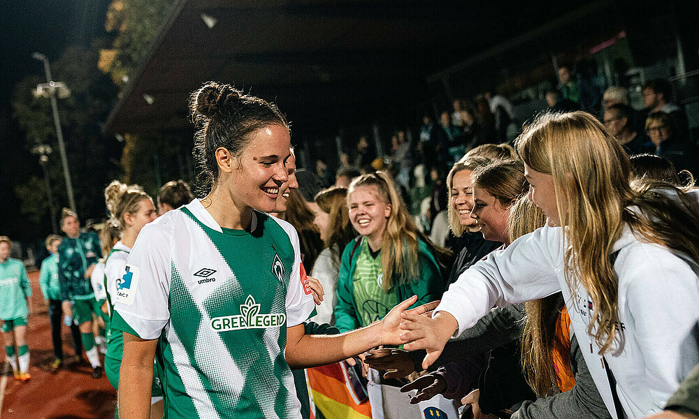 Hanna Németh klatscht an der Bande mit einem Mädchen ab.