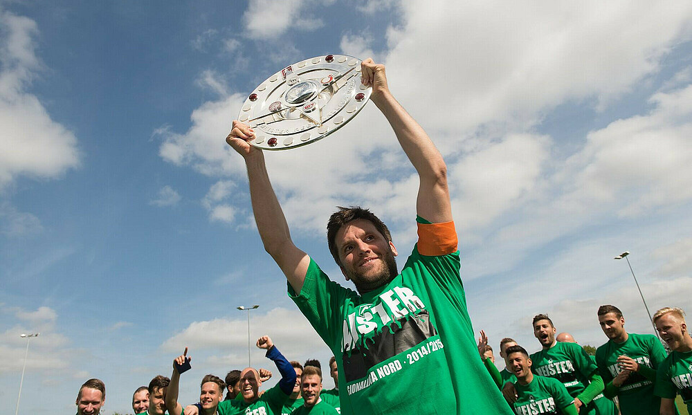 Florian Bruns hebt die Meisterschale in die Höhe. 