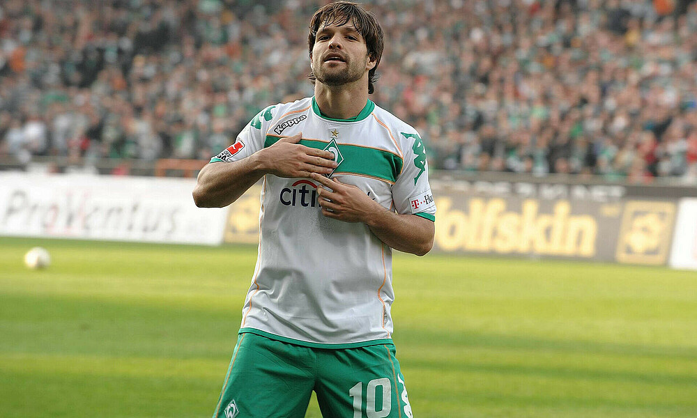 Diego hat die Hände auf dem Werder-Logo.