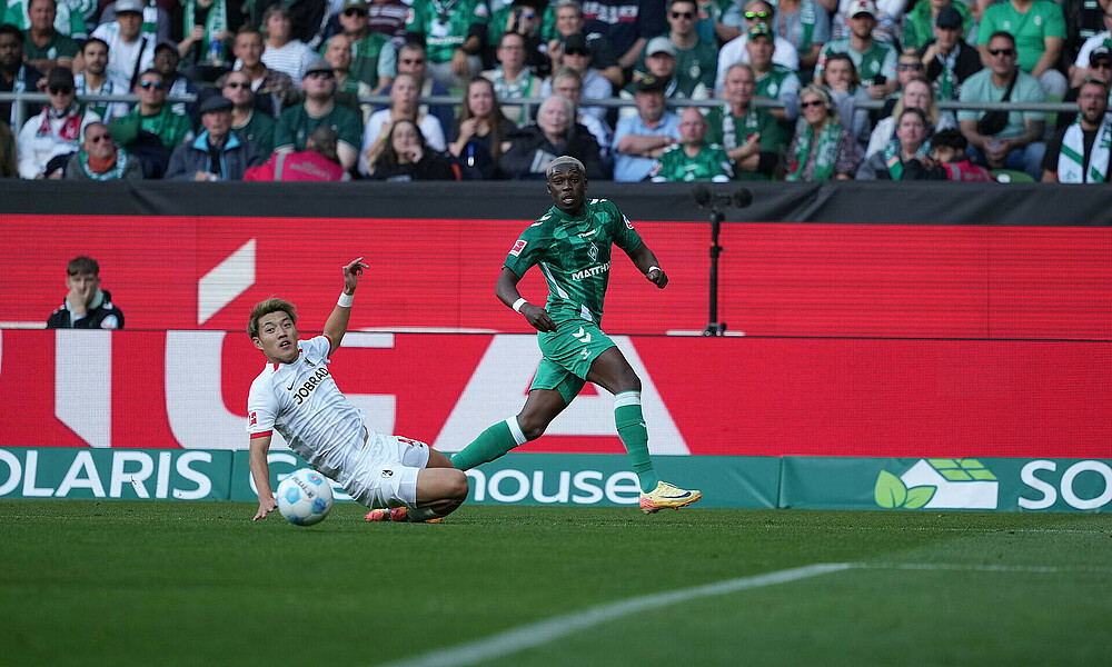 null Derrick Köhn im Duell mit Ritsu Doan gegen Freiburg im Weserstadion