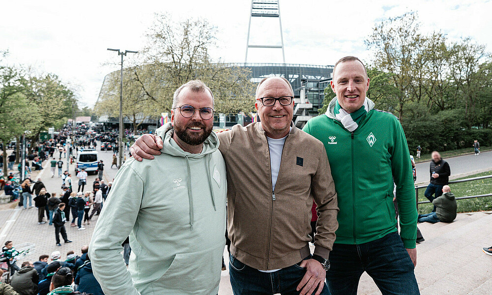 Dirk Wintermann und die Moderatoren Till und Jörn stehen vor dem Weserstadion