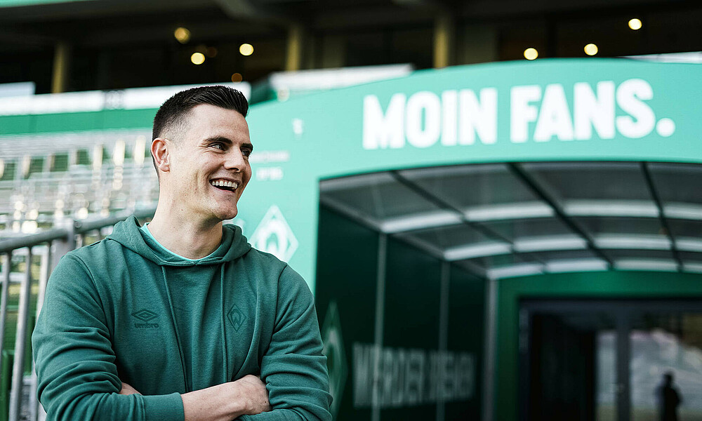 null Michael Zetterer vor dem Kabinenausgang mit verschränkten Armen und einem Lächeln.