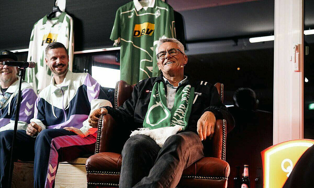 Wynton Rufer lächelt auf dem PK-Podium. 