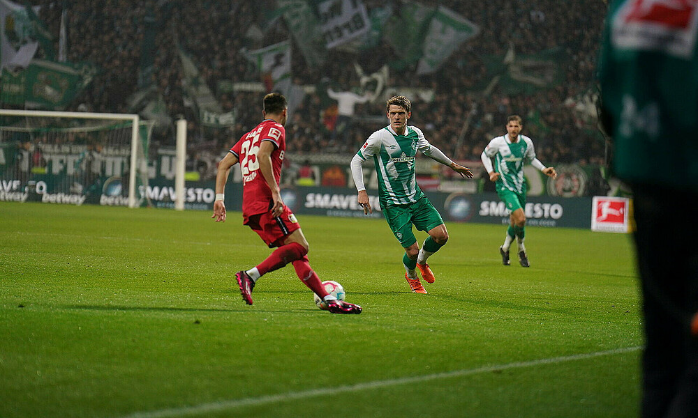 null Jens Stage läuft einen Gegenspieler an