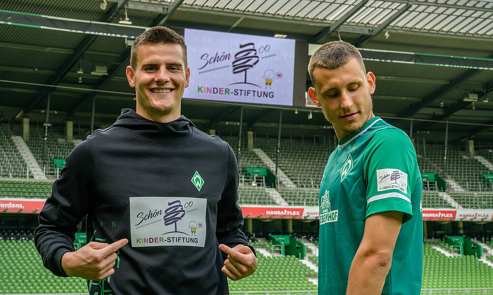 Michael Zetterer und Maximilian Eggestein posieren mit der Schön & Co KINDER-Stiftung auf dem Ärmel