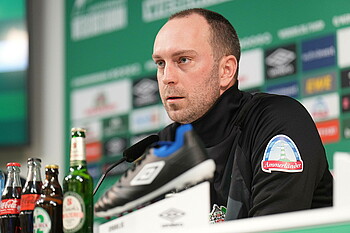 Ole Werner auf der PK vor dem Spiel gegen Frankfurt mit ernstem Gesichstausdruck.
