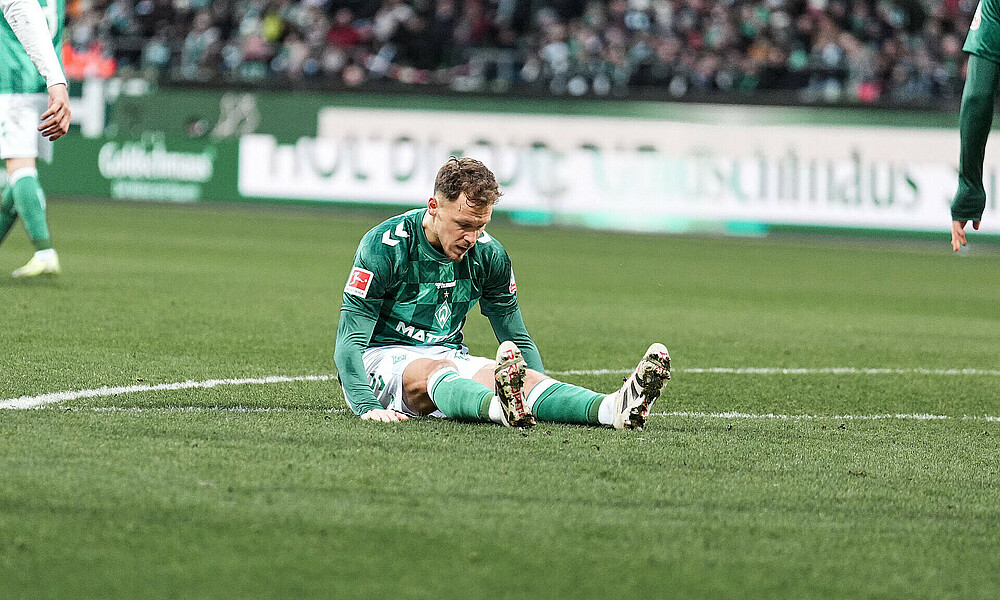 Senne Lynen sitzt auf dem Boden. 