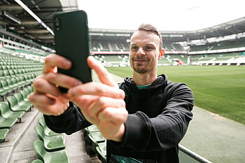 Christian Groß macht ein Selfie im wohninvest WESERSTADION