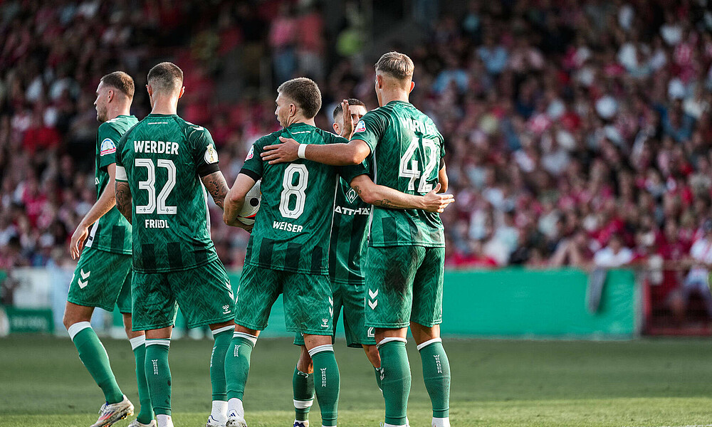 Keke Topp feiert sein Tor im Werder-Trikot im Pokalspiel gegen Energie Cottbus mit Marco Friedl, Romano Schmid, Mitchell Weiser und Marvin Ducksch.