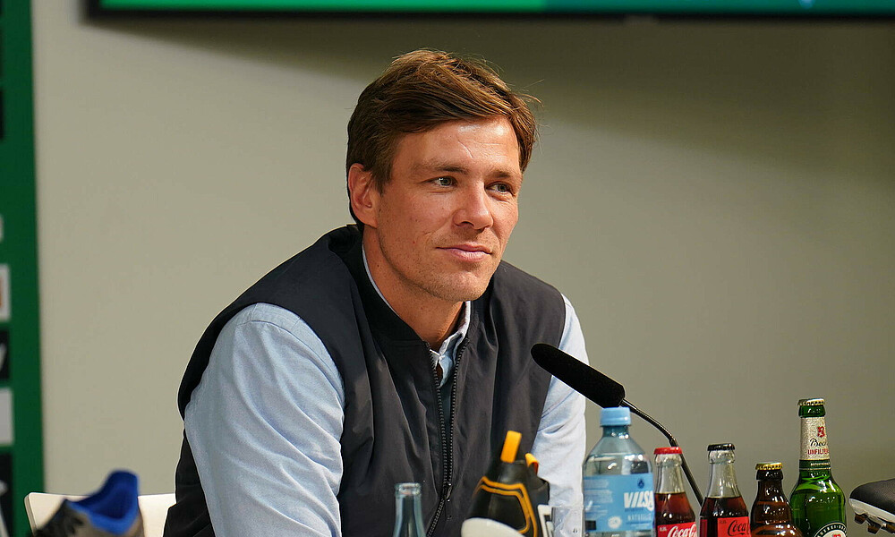 Clemens Fritz bei einer Pressekonferenz an einem Mikrofon.