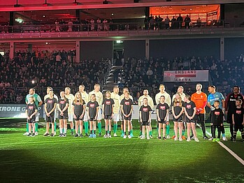 Die Spieler stehen in einer Reihe, vor ihnen Einlaufkinder.