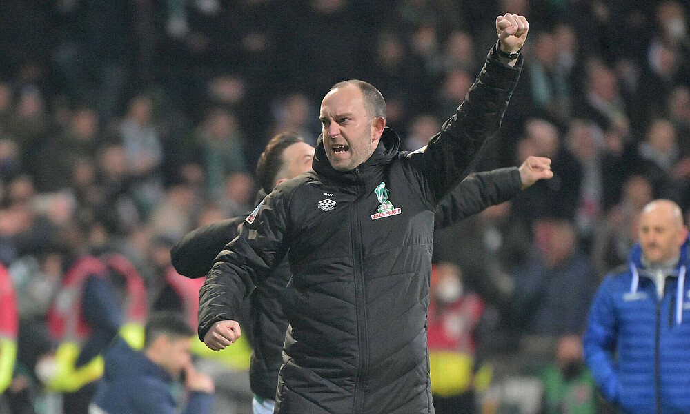 Werder-Trainer Ole Werner jubelt mit den Armen in der Luft.