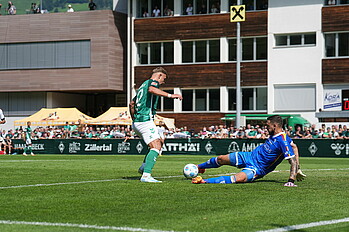 Keke Topp im Duell mit Lecce-Keeper Falcone. 