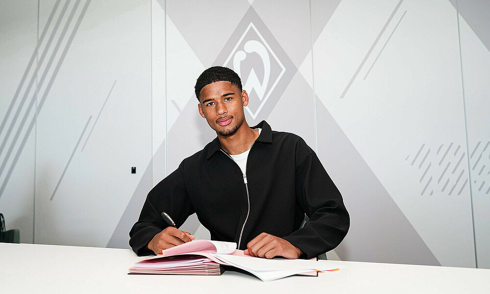 null Salim Musah unterschreibt einen Vertrag.