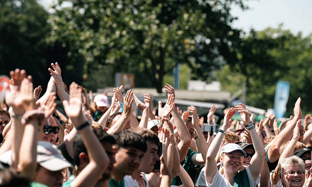 Die Fans feiern und klatschen in der ersten Reihe. 