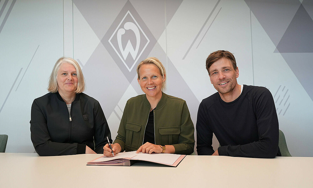 Birte Brüggemann, Fritzy Kromp und Clemens Fritz sitzen an einem Tisch und lächeln.