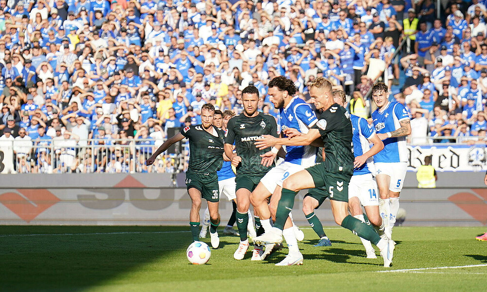 Die Spieler kämpfen um den Ball. 