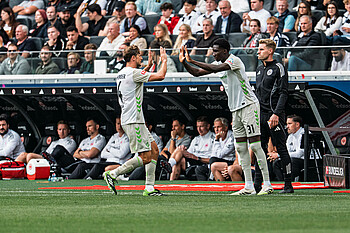 Karim Coulibaly klatscht mit Niklas Stark ab und läuft aufs Feld. Er wird gerade eingewechselt.
