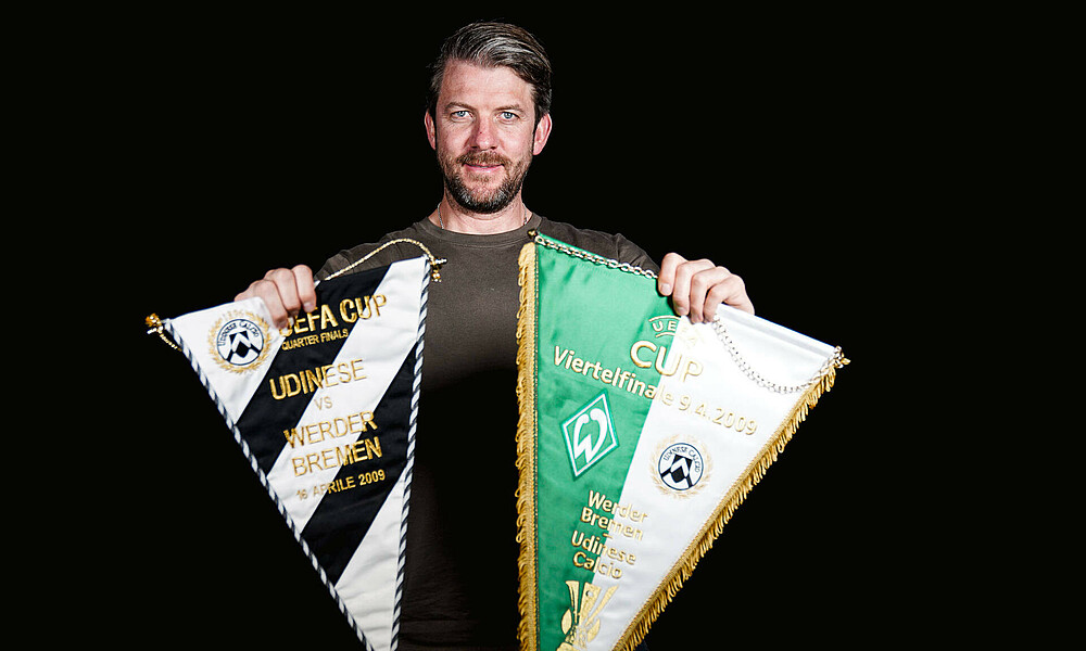 null Peter Niemeyer mit zwei Wimpeln vom Udinese-Spiel in der Hand.
