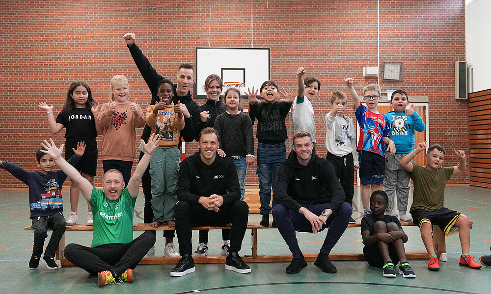 Duksch und Lynen zusammen mit den Kids beim Gruppenfoto (Foto: Werder.de)