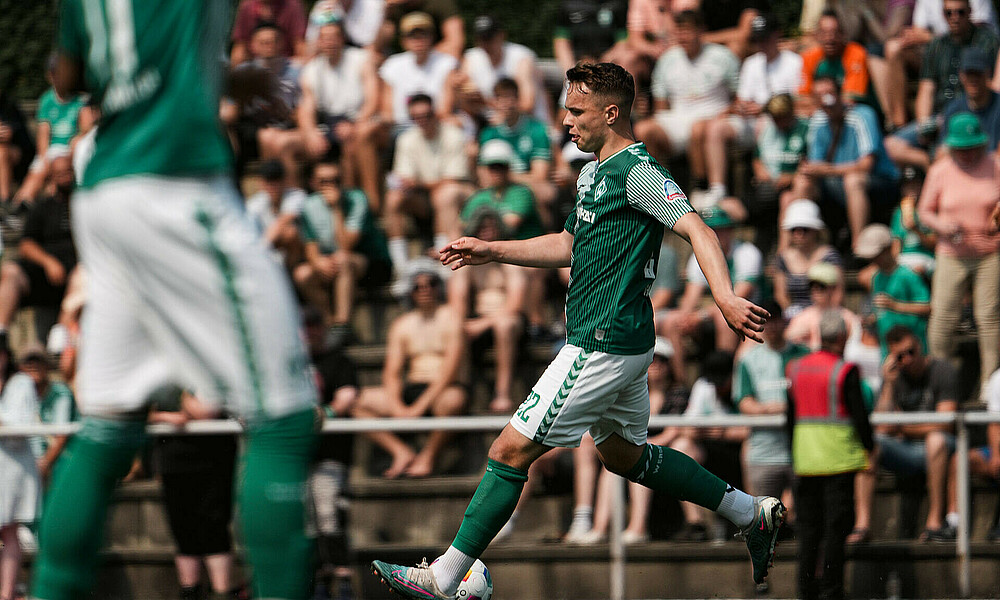 Niklas Schmidt im Werder-Heimtrikot mit Ball am Fuß. 