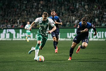 Mitchell Weiser sprintet mit Ball am Fuß an seinem Berliner Gegenspieler vorbei.