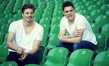 null Prödl und Junuzovic sitzen auf der Tribüne im Stadion.