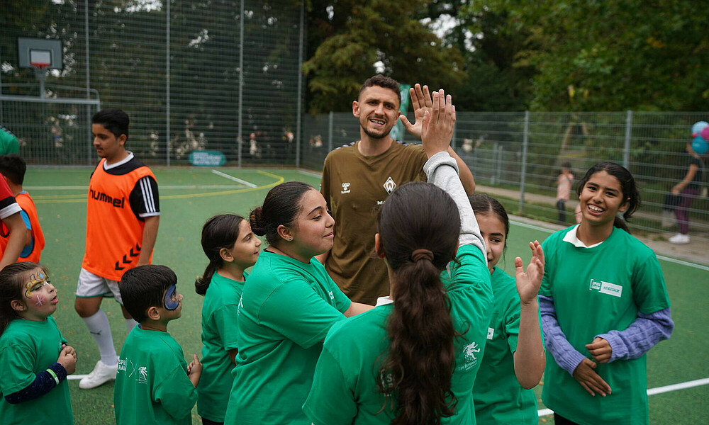Milos Veljkovic klatscht mit Kindern ab