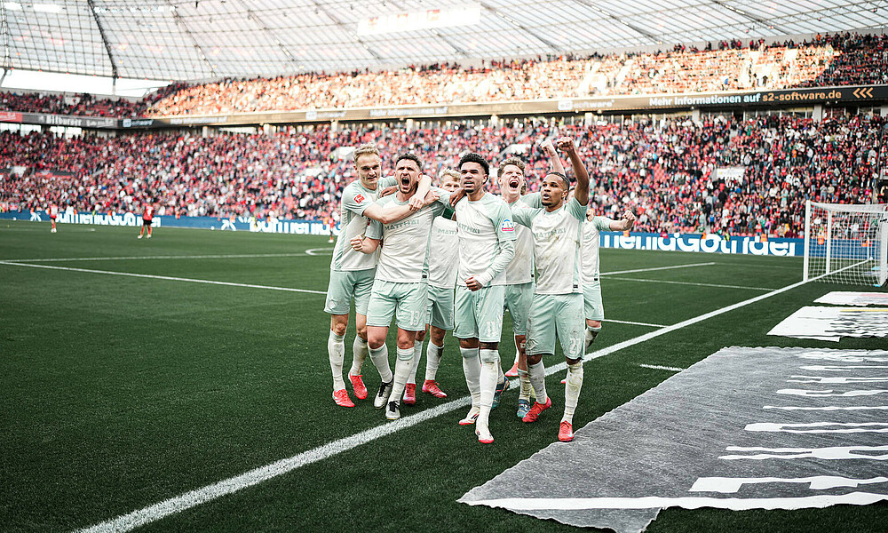 Die Mannschaft feiert das Siegtor vor der Kurve.