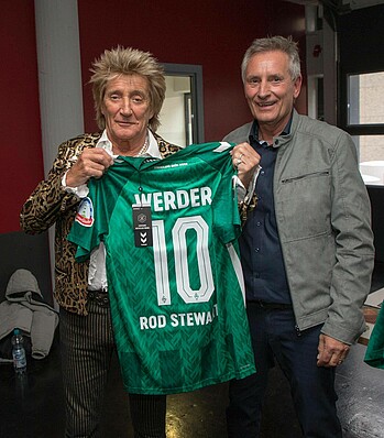 Rod Stewart bekommt ein Werder-Trikot übergeben. 