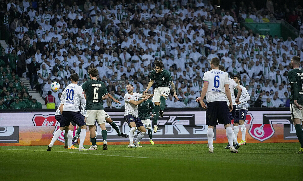 Kownacki köpft auf das Tor, steht dabei in der Luft. 