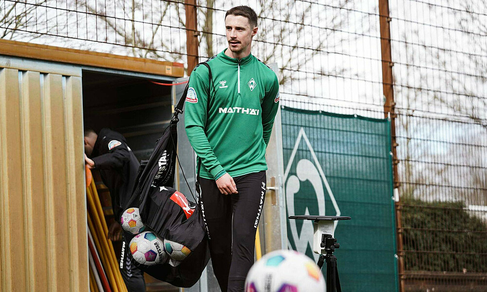 Marco Friedl mit einem Ballsack über der Schulter. 