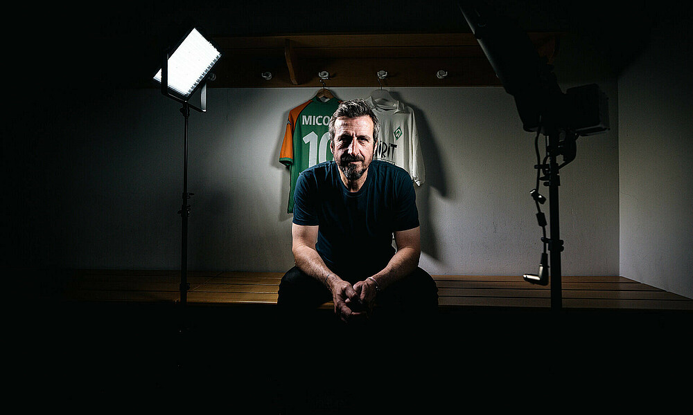 Johan Micoud in der Kabine mit zwei seiner Werder Trikots an der Wand.