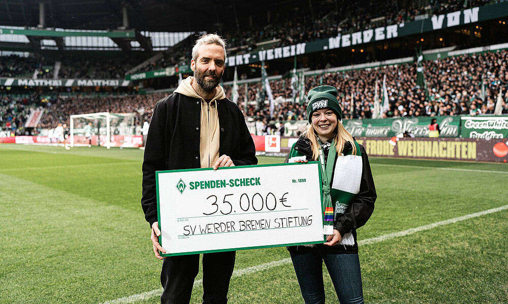 Henrik Oesau und Sina Wetzel mit dem Spendencheck in der Hand