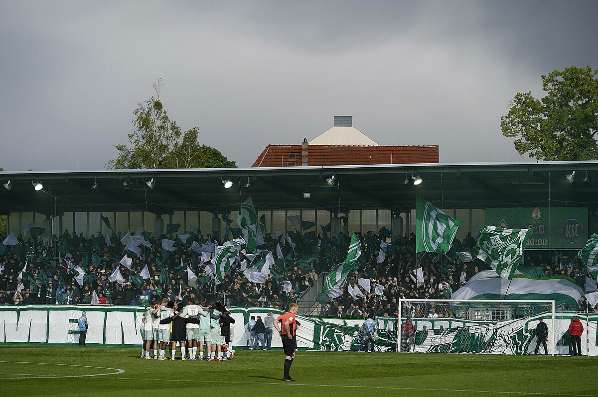 Die U19 steht im Kreis, im Hintergrund sind die Werder-Fans