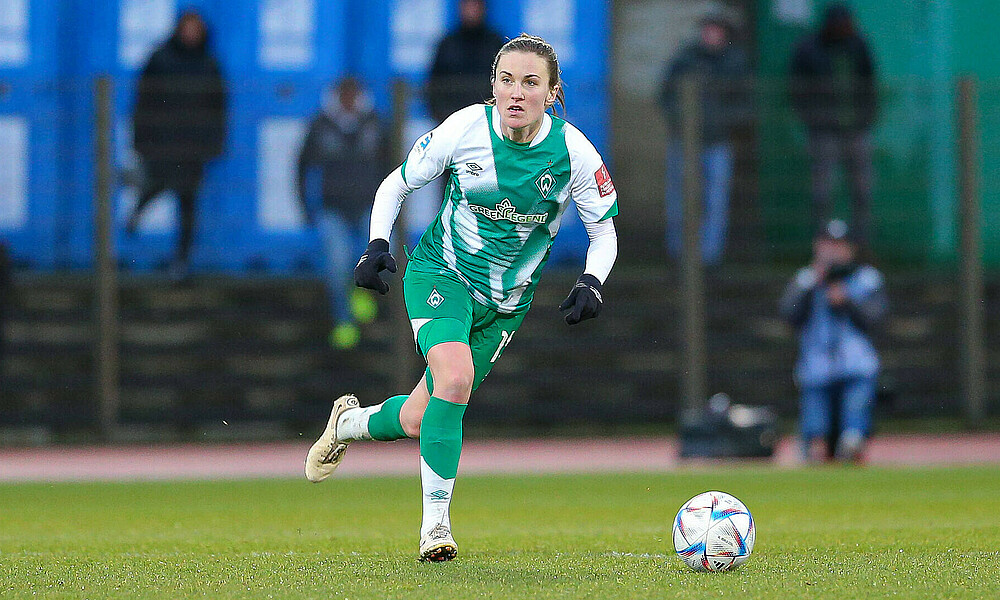 Michaela Brandenburg im grün-weißen Trikot am Ball.