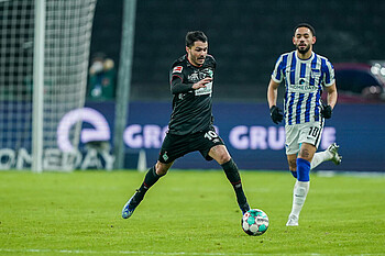null Leo Bittencourt dribbelt mit dem Ball am Fuß, der Gegenspieler verfolgt ihn.
