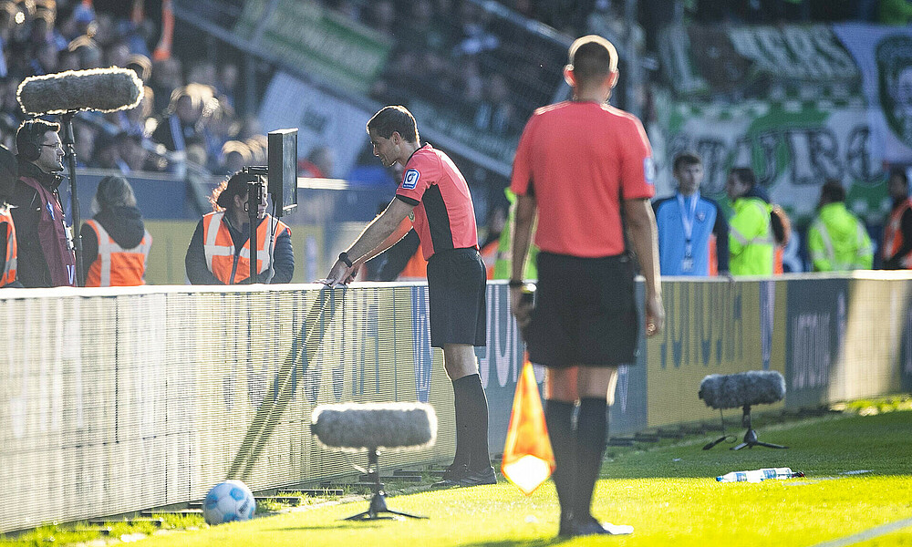Dr. Burda schaut sich eine Szene auf dem Monitor an. 