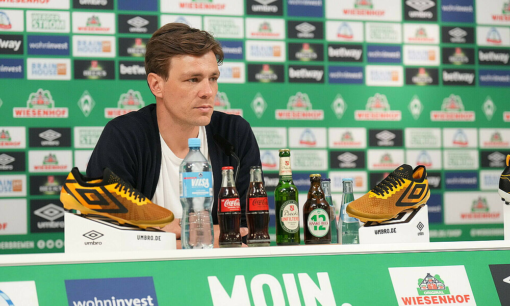 Clemens Fritz am Mikrofon im PK-Raum des wohninvest WESERSTADIONS.