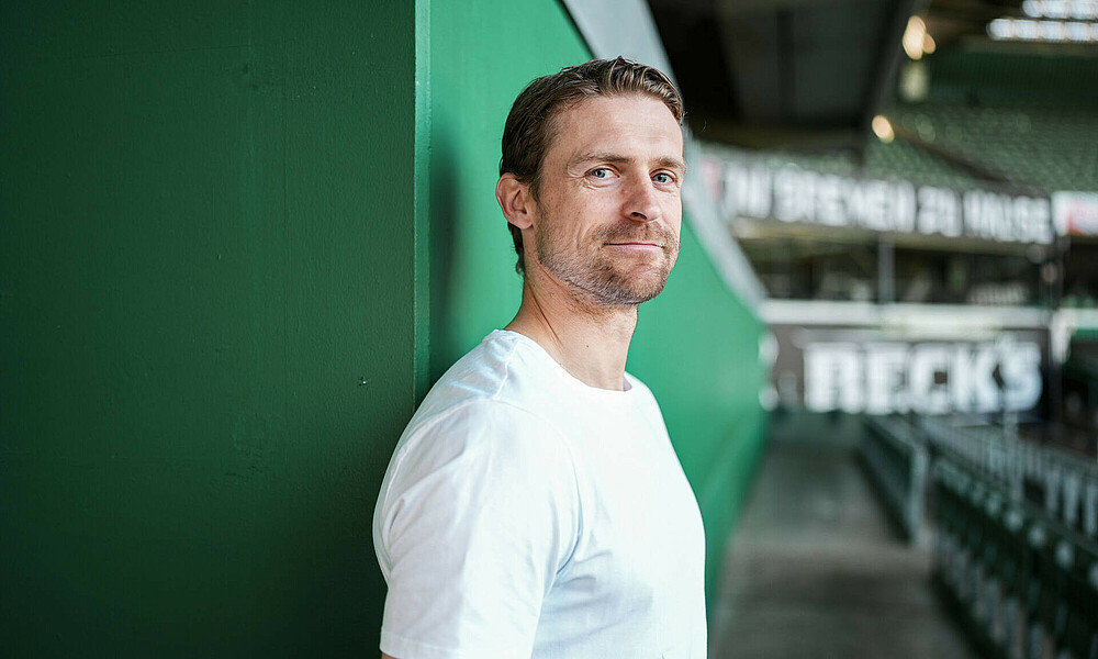 null Oliver Hüsing in einem weißen T-Shirt in der Ostkurve.