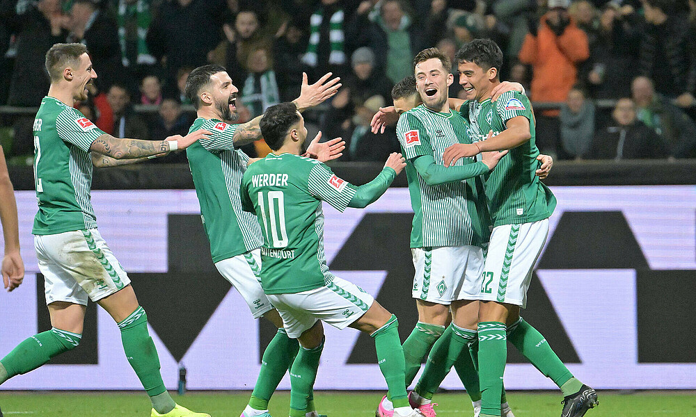 Werder Spieler stürmen auf Malatini hinzu, der das 3:1 für Werder gegen Freiburg erzielt hat