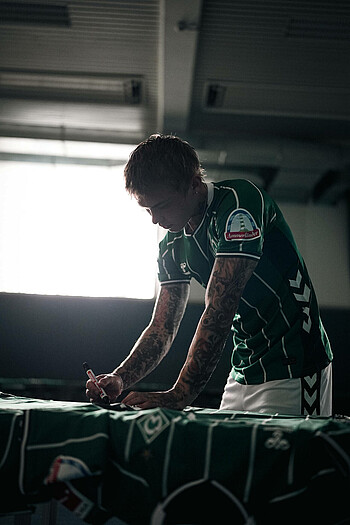 Isak Hansen-Aarøen unterschreibt ein Trikot. 