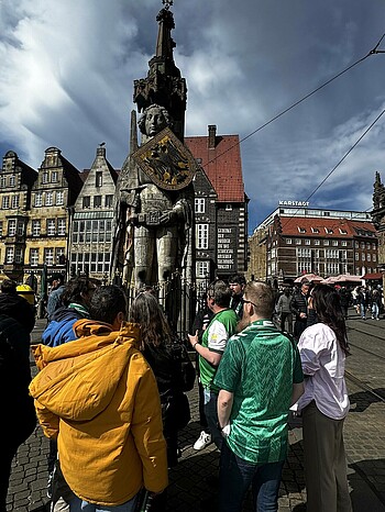 Werder-Fans stehen vor der Statue Bremer Roland