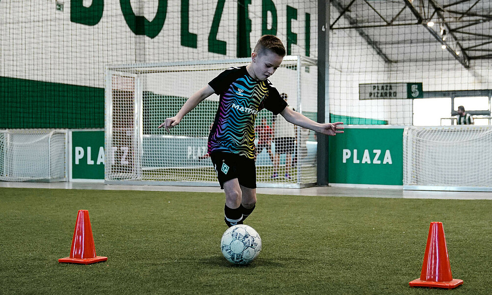 Ein Kind dribbelt durch einen Parcour