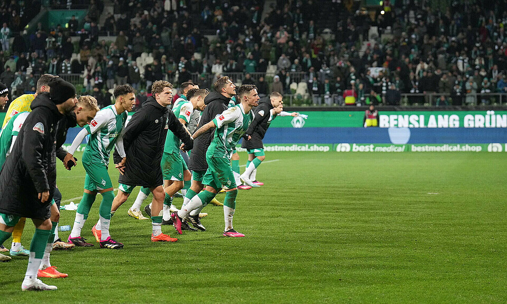 null Die Mannschaft hebt vor der Ostkurve die Arme.